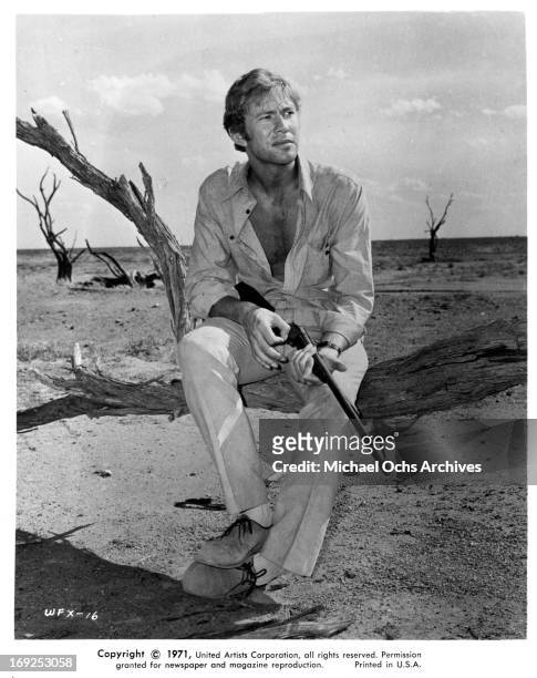 Gary Bond holds a gun in a scene from the film 'Wake In Fright', 1971.