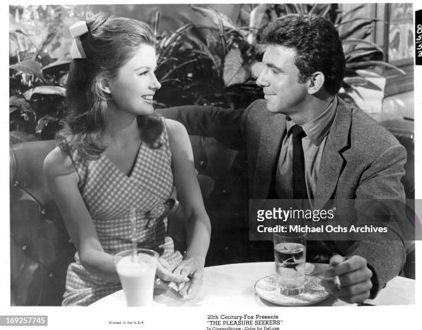 Pamela Tiffin has a drink with Anthony Franciosa in a scene from the film 'The Pleasure Seekers', 1964.