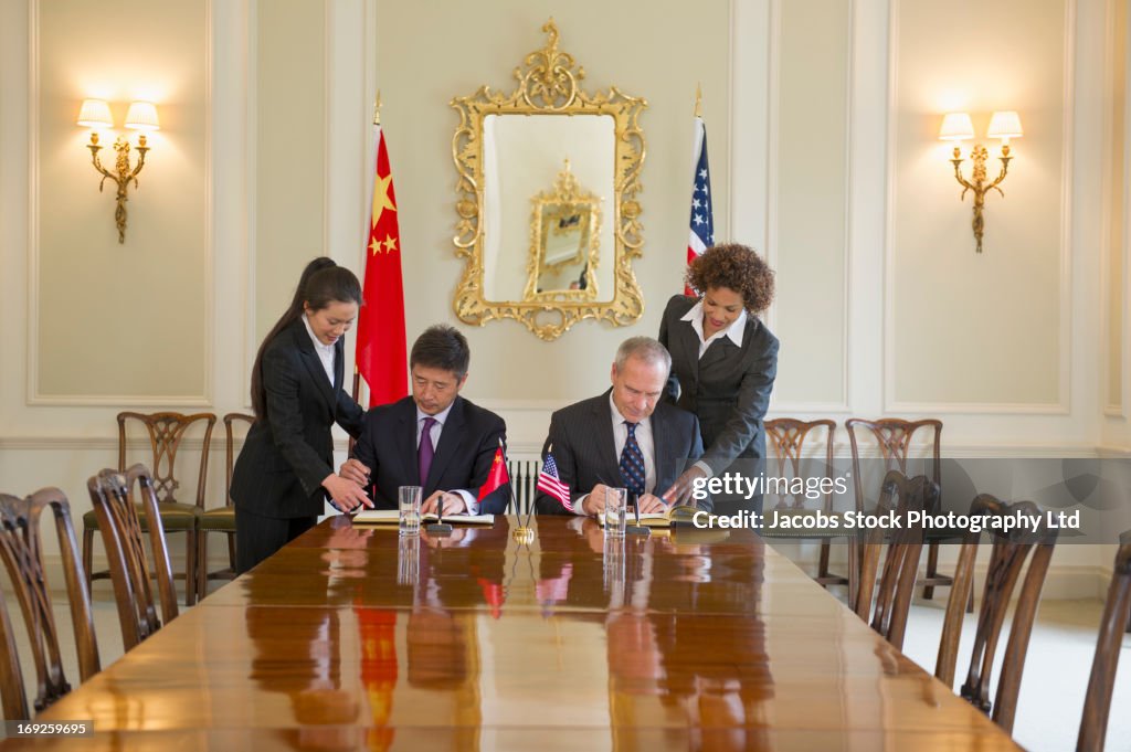 Business people signing contracts