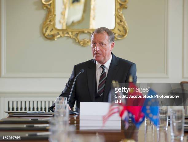 caucasian businessman talking in microphone - diplomat stock-fotos und bilder