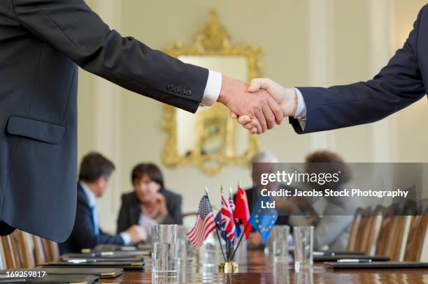 businessmen shaking hands in meeting - british and eu flag bildbanksfoton och bilder