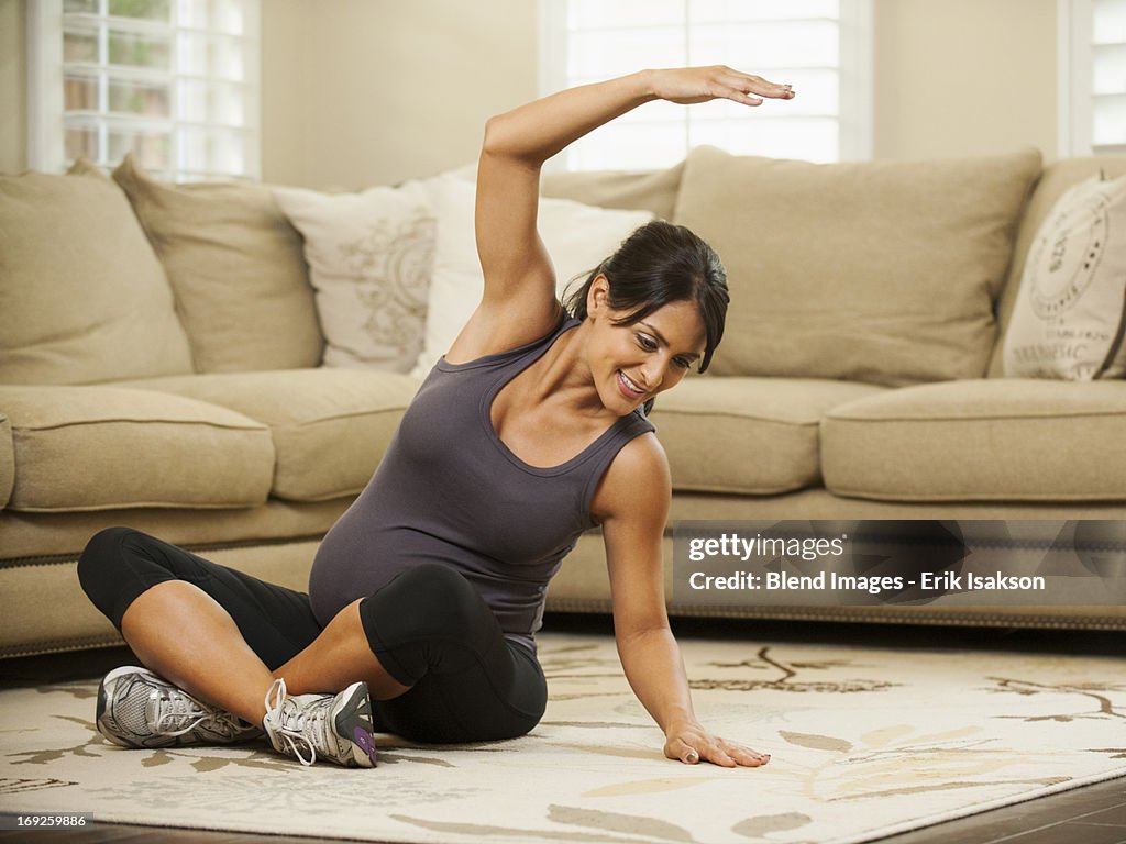 Pregnant Hispanic woman stretching