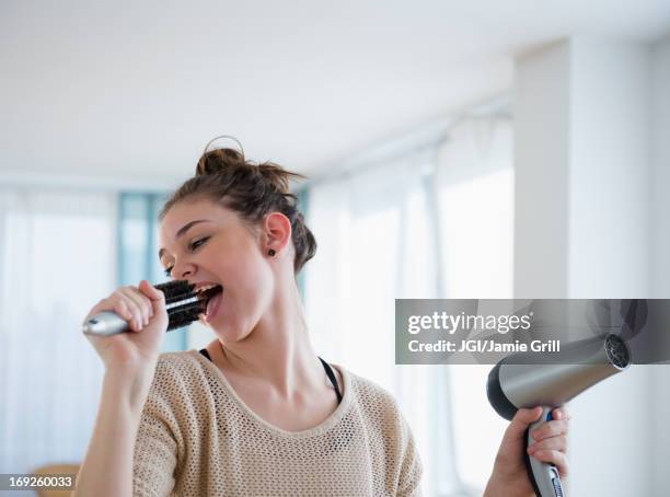 hispanic girl singing into hairbrush - girls getting ready imagens e fotografias de stock