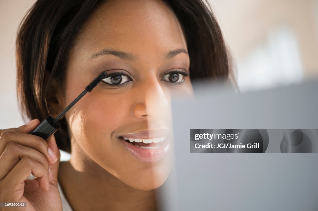 African American woman applying makeup