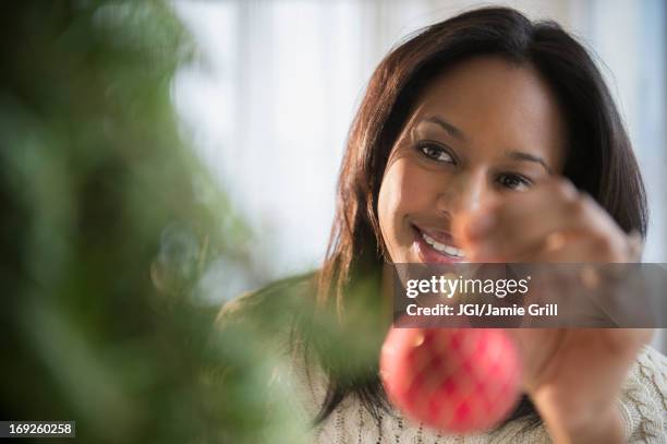african american woman decorating christmas tree - decorating the christmas tree stock pictures, royalty-free photos & images