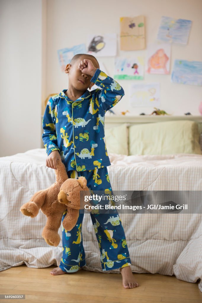 African American boy waking up in bedroom