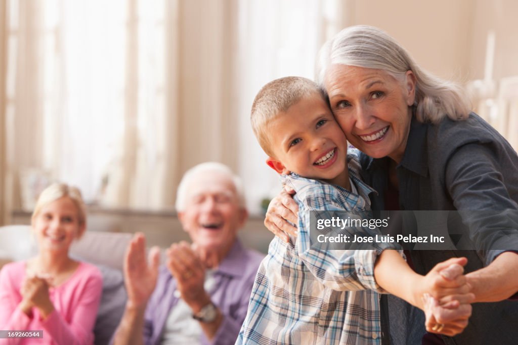 Caucasian woman dancing with grandson