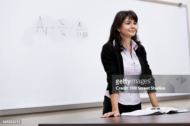 caucasian teacher standing at whiteboard - lecturer whiteboard stock pictures, royalty-free photos & images