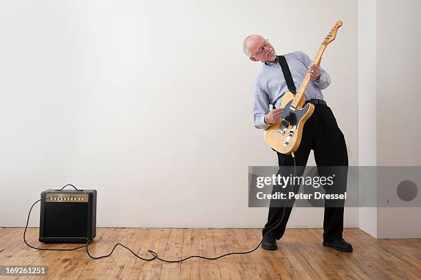 caucasian man playing electric guitar - amplificador fotografías e imágenes de stock