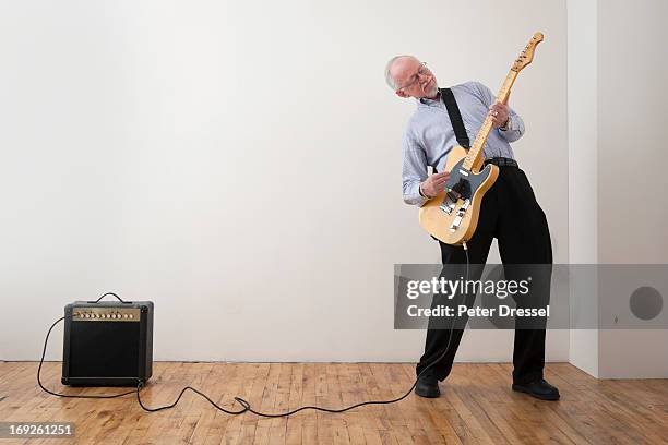 caucasian man playing electric guitar - versterker stockfoto's en -beelden