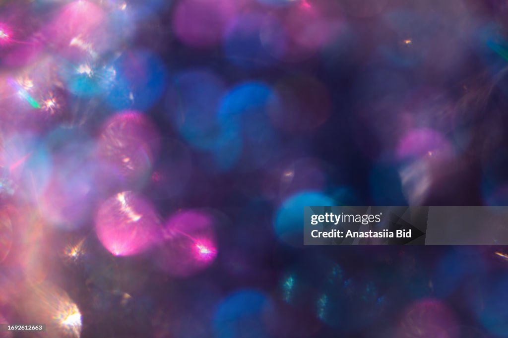 Abstract defocused purple holographic background with shining glitter.Good as overlay layer.