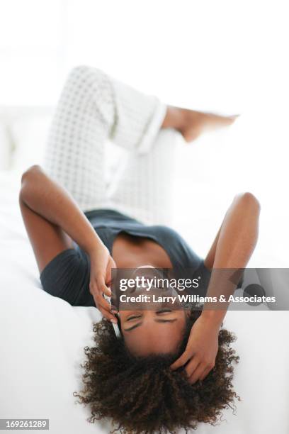 black woman talking on cell phone - bed on white stock pictures, royalty-free photos & images