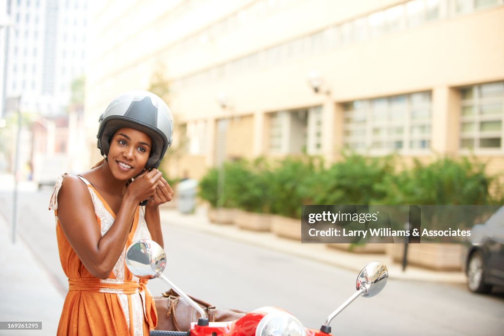 Black woman tying on helmet
