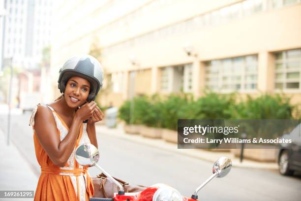 black woman tying on helmet - mobility scooter photos et images de collection