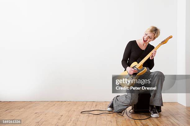 caucasian woman playing electric guitar - woman playing guitar stock pictures, royalty-free photos & images