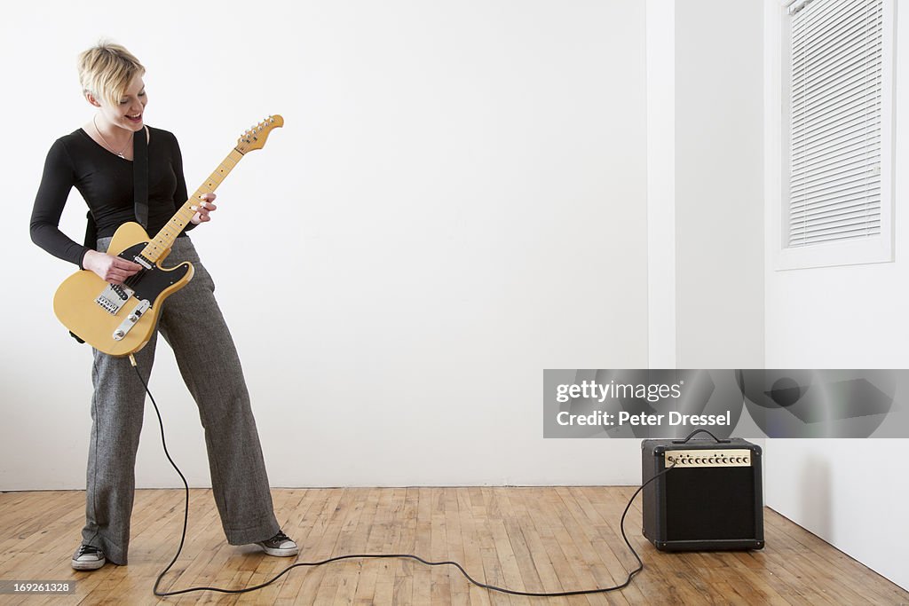 Caucasian woman playing electric guitar