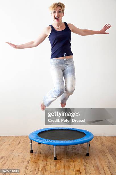 caucasian woman jumping on indoor trampoline - trampoline jump stock pictures, royalty-free photos & images
