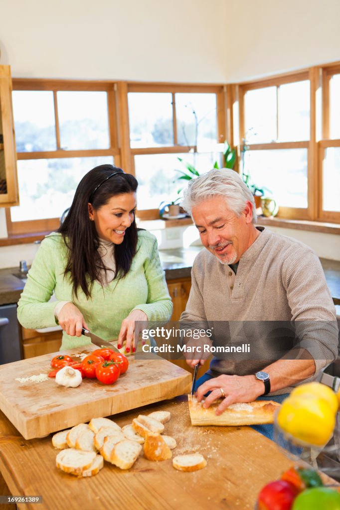 Hispanic couple cooking together in kitchen