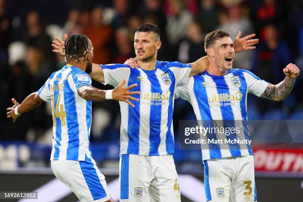 Matty Pearson of Huddersfield Town celebrates with teammates Josh Ruffels and Sorba Thomas after scoring the team's first goal during the Sky Bet...