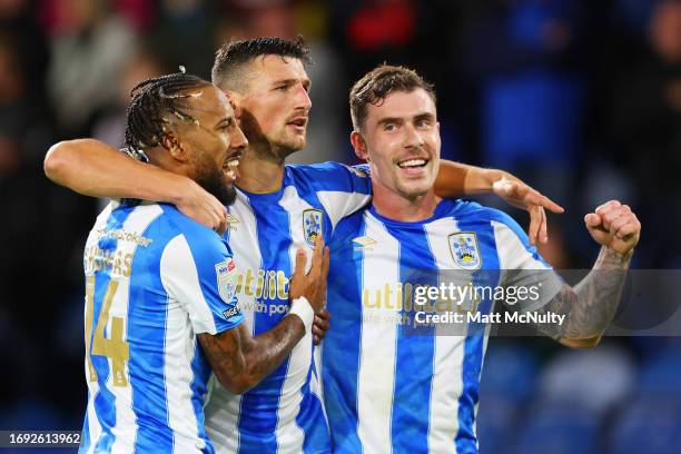 Matty Pearson of Huddersfield Town celebrates with teammates Josh Ruffels and Sorba Thomas after scoring the team's first goal during the Sky Bet...