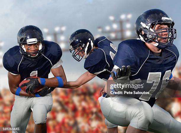 football players passing ball - american football lineman stockfoto's en -beelden