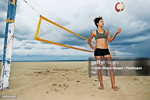 mixed race woman playing with volleyball on beach - redondo beach stock pictures, royalty-free photos & images