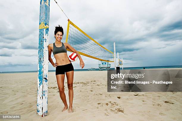 mixed race woman holding volleyball on beach - redondo beach stock pictures, royalty-free photos & images