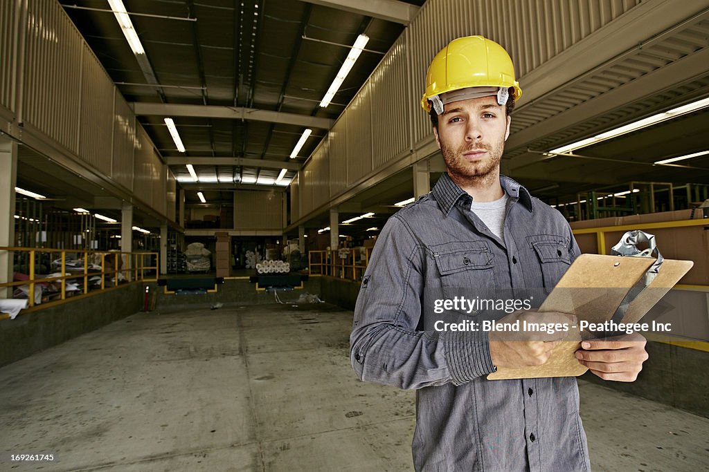 Caucasian worker with clipboard in warehouse