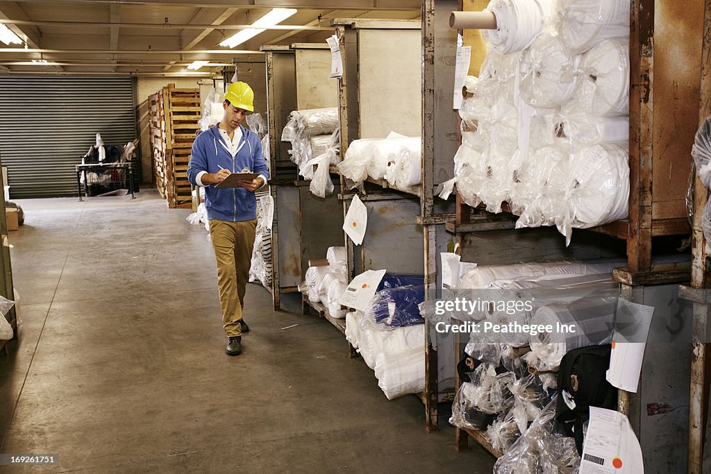 Caucasian worker checking product in warehouse