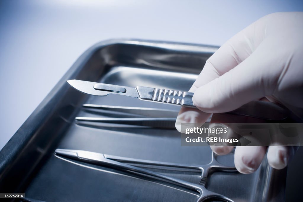 Close up of Hispanic doctor holding surgical equipment