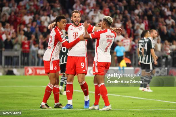 Serge Gnabry of Bayern Munich celebrates with team mates Jamal Musiala and Harry Kane after scoring their sides second goal during the UEFA Champions...