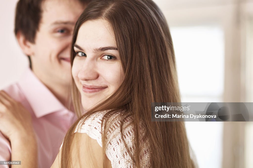 Smiling couple hugging indoors