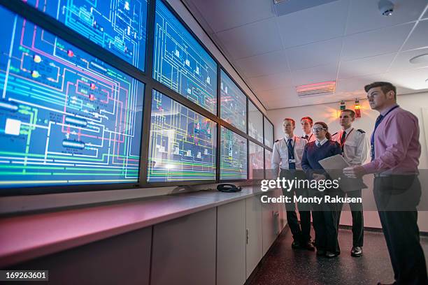 tutor and students looking at monitors in ship's engine room simulator - boot camp stock pictures, royalty-free photos & images