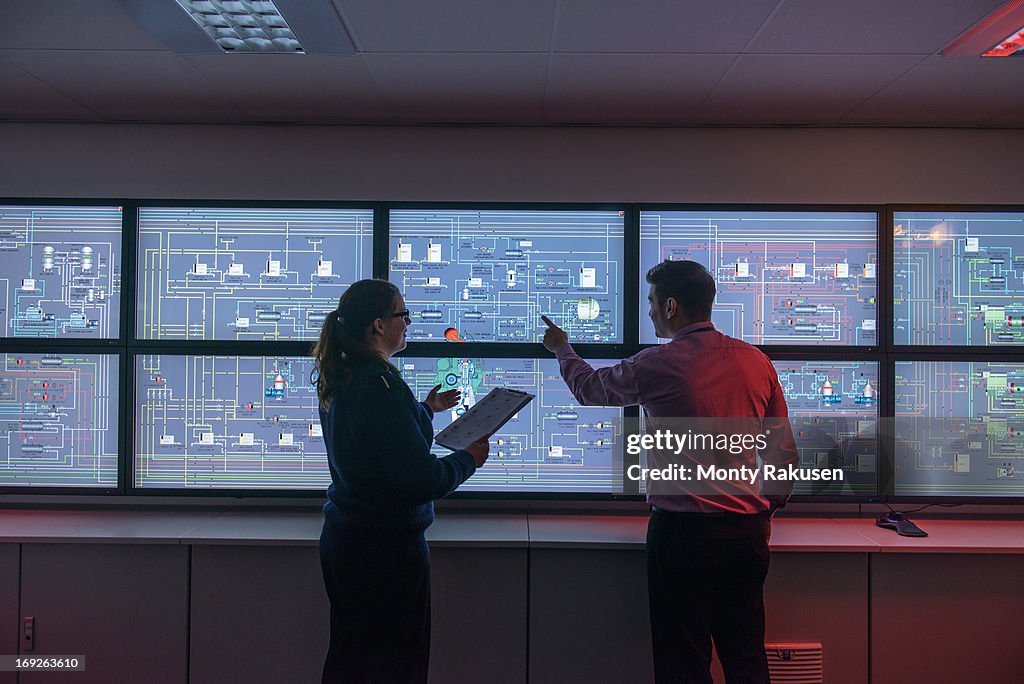 Tutor and student in front of monitors in ship's engine room simulator