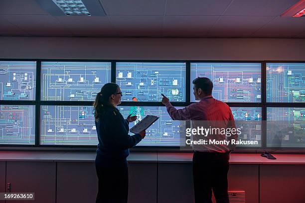 tutor and student in front of monitors in ship's engine room simulator - sala di controllo foto e immagini stock