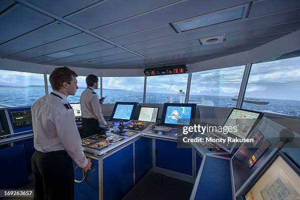 students operating equipment in ship's bridge simulation room - steering ship stock pictures, royalty-free photos & images