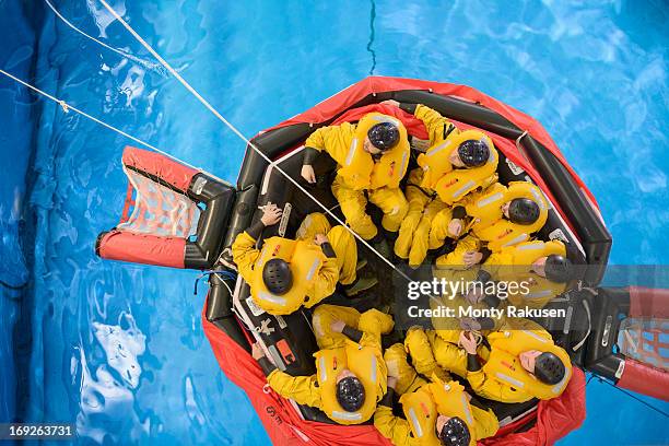 offshore oil workers in raft being trained in sea ditching survival in pool facility, overhead view - rettungsboot stock-fotos und bilder