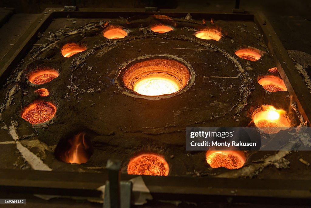 Molten metal glowing in moulds in foundry