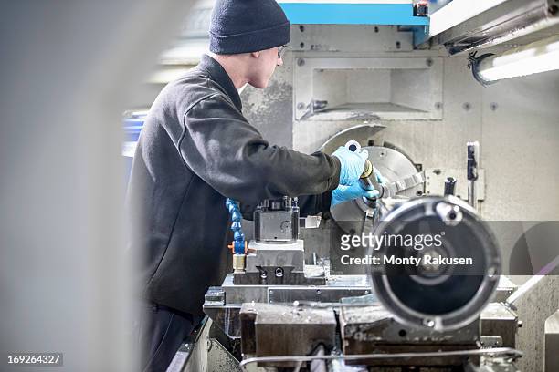 engineer working on industrial lathe in engineering factory - drehmaschine stock-fotos und bilder