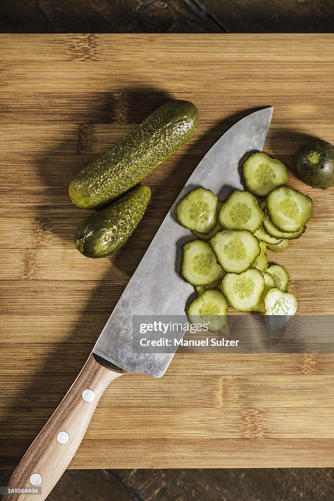 Knife with chopped pickles on table