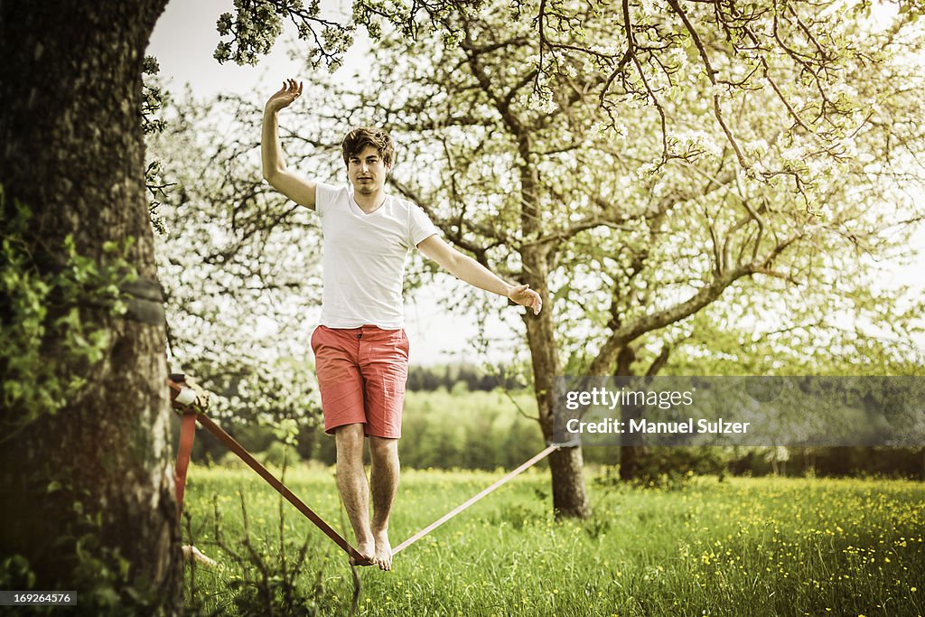 Man walking on tightrope in field