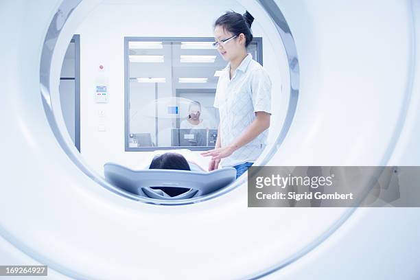 technician with patient in ct scanner - hospital machine stockfoto's en -beelden