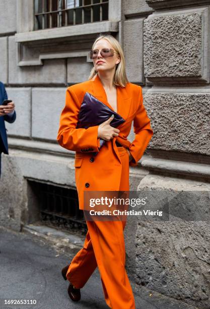 Guest wears orange suit outside Iceberg during the Milan Fashion Week - Womenswear Spring/Summer 2024 on September 20, 2023 in Milan, Italy.