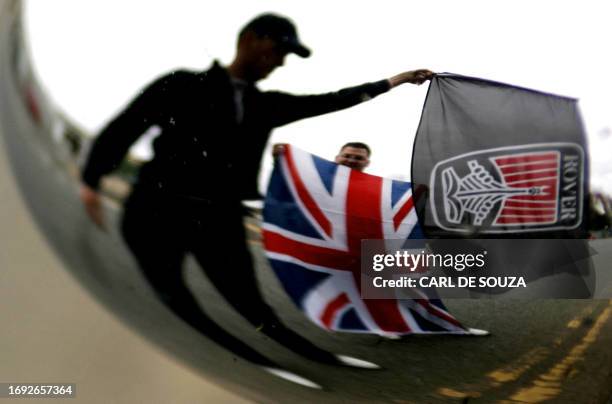 Protestors waving flags are shown an automobile rear view mirror outside the Rover Longbridge car plant in Birmingham, England, 11 April, 2005....