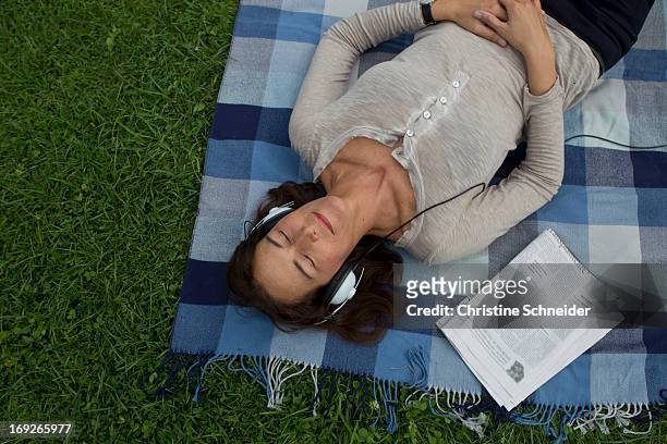 woman listening to headphones in grass - nature magazine 個照片及圖片檔