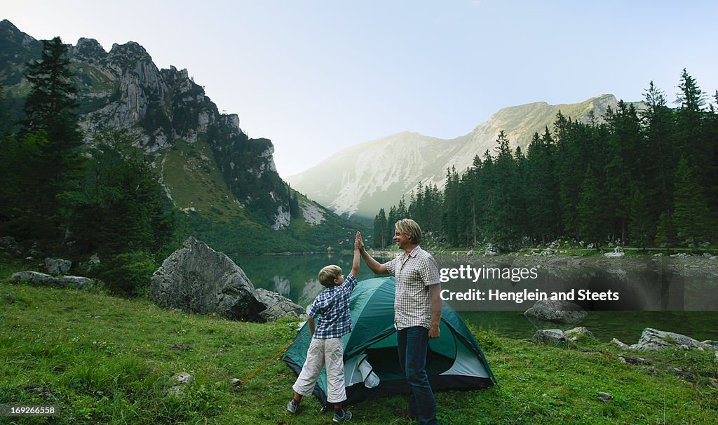 Father and son pitching tent together