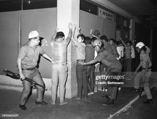 Filipino soldiers frisk student demonstrators in the wake of a march on the American Embassy. Troops turned back about 2,000 snake-dancing students...