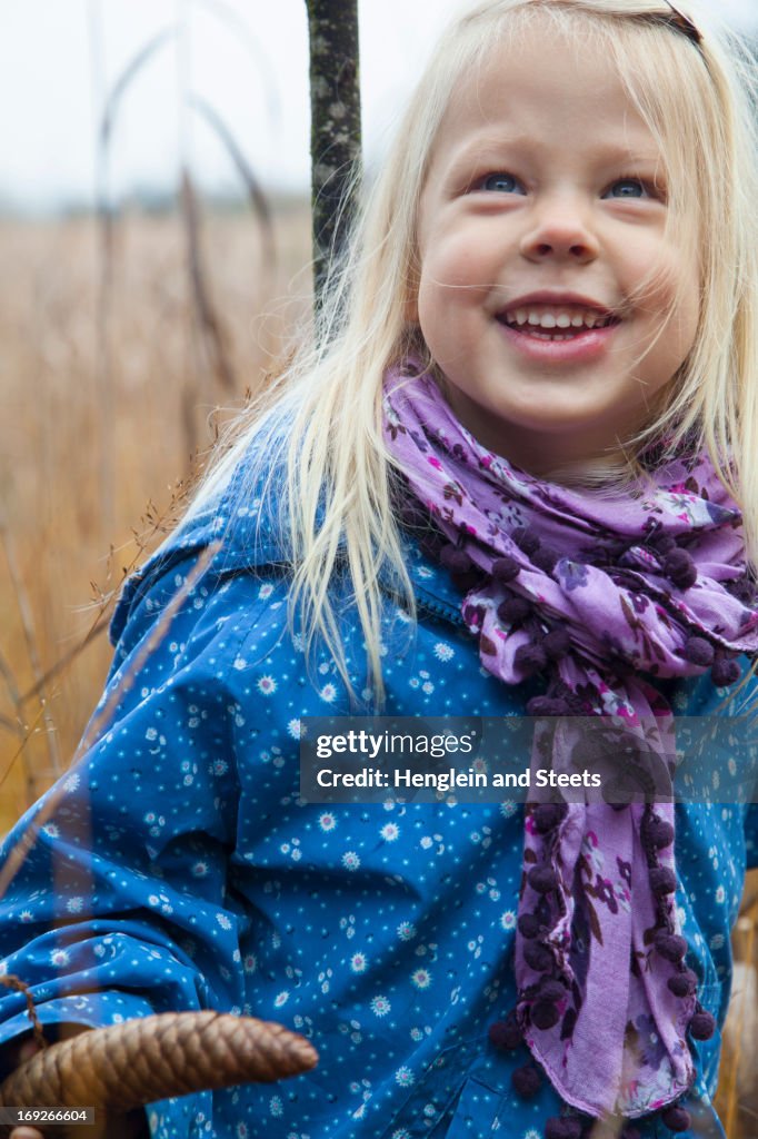 Smiling girl standing in tall grass