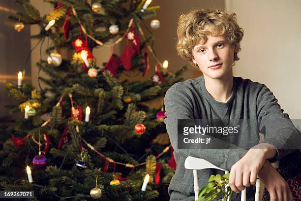 teenage boy sitting by christmas tree - one teenage boy only 個照片及圖片檔