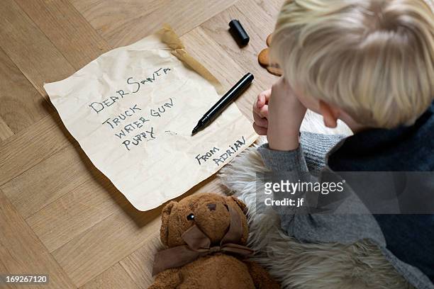 boy writing christmas list for santa - blond boy stock-fotos und bilder